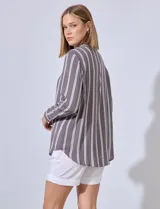 Camisa celeste con rayas verticales blancas, de corte clásico, cuello a la base, escote en V y cierre frontal con botones.