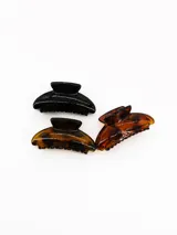 Set de tres pinzas para el cabello de diferentes colores: una negra sólida, una carey oscura y una carey clara.