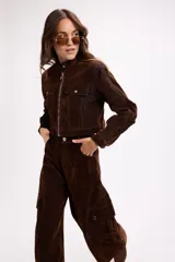 Pantalón cargo de tiro medio, confeccionado en terciopelo negro. Presenta corte amplio, bolsillos laterales con solapa y cierre frontal con botón y cremallera.