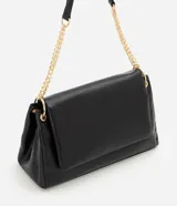 Cartera shoulder grande de cuero sintético negro con textura símil cocodrilo, solapa frontal con cierre magnético y asa de hombro combinada con cadena y herrajes metálicos dorados.