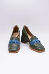 Zapato de cuero verde con aplique de cuero azul y botones forrados.