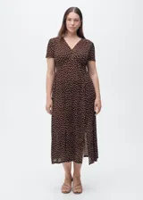 Vestido midi de corte recto con estampado de lunares, cuello en pico y mangas cortas. Presenta cierre de cremallera lateral y abertura en el bajo.