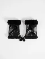 Mitones de cuero sintético negro con interior de pelo sintético, diseño sin dedos y detalle de cordones ajustables en el lateral.