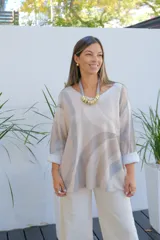 Collar de diseño artesanal compuesto por múltiples tiras de cuero gamuzado en color gris claro, adornado con una serie de piezas cilíndricas de metal dorado con textura martillada.