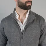 Campera tejida color marrón claro con cierre frontal, cuello alto y mangas largas con puños acanalados.