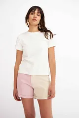 Short de denim bicolore estilo patchwork, con una pierna en tono rosado y la otra en beige.
