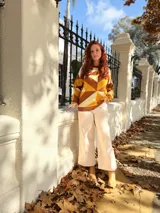 Sweater de punto con diseño geométrico en tonos mostaza, marrón y beige.