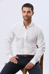 Camisa de vestir blanca entallada, de manga larga, cuello camisero y cierre frontal de botones, con elastano añadido para mayor confort.