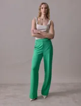 Pantalón naranja de crepe elastizado, corte recto, con bolsillos delanteros y apliques de botones metálicos.