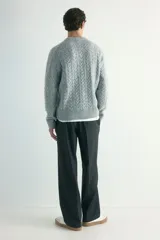 Pantalón de corte relajado y pierna recta, confeccionado en tejido suave de color negro. Presenta cintura elástica con cordón de ajuste, pliegues frontales y traseros, bolsillos laterales discretos y un bolsillo posterior insertado.