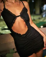 Minivestido negro con escote en V profundo y abertura en el abdomen, con volados en los bordes y breteles finos.