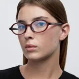 Lentes blueblocker con armazón ovalado de color bordó translúcido y protección para pantallas.