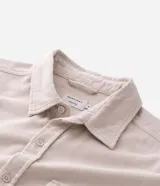 Camisa de hombre de corte regular confeccionada en terciopelo de algodón, con cuello clásico, cierre frontal de botones y dos bolsillos con solapa en el pecho.