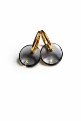 Aros de argolla dorada de acero quirúrgico con dije circular de resina traslúcida en tono gris humo y detalle de cristal incrustado.
