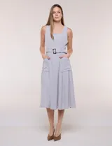 Vestido midi blanco de la marca Nina Leonard, sin mangas y con escote cuadrado. Cuenta con corte en la cintura, bolsillos laterales con solapa, falda fluida con detalle de frunce inferior e incluye un cinturón del mismo género con hebilla carey.