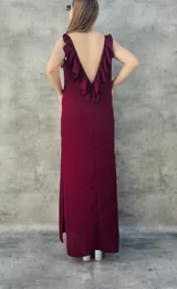 Vestido largo color bordó, con espalda descubierta y volados en el escote.