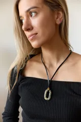 Collar con tiento negro y dije de piedra natural ovalada en tonos grises y azules.
