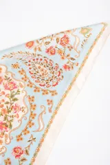 Pañuelo cuadrado de poliéster con estampado tipo paisley y floral en tonos celestes, blancos, rosados y anaranjados.