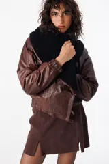 Campera de cuero marrón con cuello solapa, corte holgado y cierre frontal con un botón.