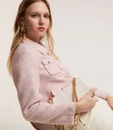 Campera corta de tweed color rosa, con cuello camisero, bolsillos delanteros con solapa y botones dorados estilo escudo.