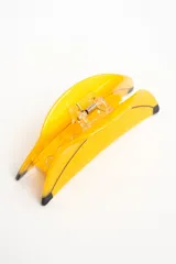 Broche para el pelo en forma de banana, color amarillo con detalles en negro, fabricado en acetato.