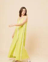 Vestido largo blanco de lino con escote en V y flecos de algodón en los bordes.