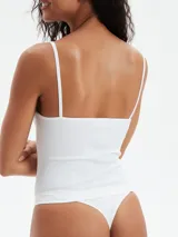 Musculosa blanca de tejido acanalado, con escote en V y tirantes finos.