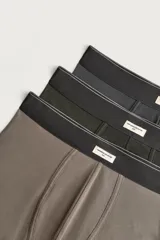 Pack de tres bóxers en colores marrón, verde militar y gris oscuro, con cintura elástica y etiqueta frontal distintiva.
