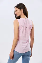Musculosa de lino color beige, con cuello mao y escote en V, cierre frontal con botones y dos bolsillos plaqué con solapa en el pecho.