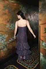 Vestido largo con diseño fruncido en todo el cuerpo, tirantes finos removibles, escote recto y falda con volados asimétricos y tajo lateral. Presenta un estampado de efecto tie-dye en tonos marrones y beige.