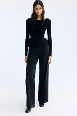 Top de punto acanalado entallado, con escote bote, mangas largas y detalle de peplum con vuelo en la cintura.