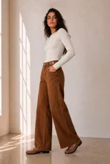 Jeans modelo Rul de corte wide leg en color bordó con efecto gastado, tiro alto y terminación desmechada en el bajo.