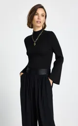 Sweater de tejido de punto fino con textura acanalada, color negro, de cuello alto y mangas largas con terminación acampanada.