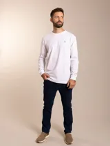 Remera blanca de manga larga con cuello redondo y logo bordado de un pájaro en el pecho.