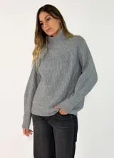 Sweater de punto acanalado en color gris, con cuello alto y mangas largas de corte raglán.