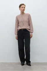 Sweater de punto color beige claro, con escote bote y tejido calado con diseño ondulado. Es de manga larga y corte recto.