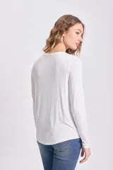 Remera de manga larga color blanco, con cuello redondo y corte holgado, confeccionada en viscosa.