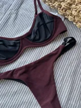 Bottom de bikini colaless, color negro en la parte trasera y bordeaux en la parte delantera. Confeccionado en lycra premium, sin costuras y con breteles regulables en los costados.