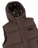 Chaleco puffer acolchado color marrón con capucha integrada. Presenta cierre frontal con botones a presión y parche con logo de la marca en el pecho. Diseño sin mangas con ajuste regular.