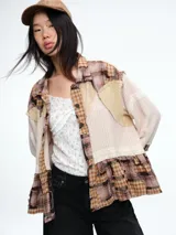 Camisa de diseño patchwork con cierre frontal de botones, confeccionada mediante la combinación de diferentes texturas y patrones en tonos tierra.