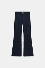 Pantalón de tiro alto confeccionado en crepe, con corte evasé y costuras frontales marcadas. Incluye un cinturón ajustable del mismo tejido con hebilla metálica y presenta cremalleras laterales ocultas en el bajo.