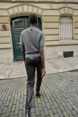 Jersey de cuello redondo color gris, con abalorios joya en el cuello, manga corta y tejido efecto cepillado. Cierre en la espalda con abertura y botón.