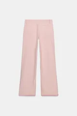 Pantalón jeans de tiro medio, corte ancho (loose), color rosa pálido. Presenta bolsillos plastrón tanto en el frente como en la espalda.