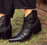 Botas texanas de caña baja confeccionadas artesanalmente en cuero vacuno, tanto en su exterior como en su forro interior. Presentan un diseño con detalle de arrugas en el empeine, cierre lateral y taco cuadrado de 5 cm.