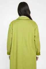 Chaqueta larga de corte relajado color verde pistacho, con solapas clásicas y bolsillos frontales con solapa. Presenta un diseño abierto sin botones, ideal para un estilo casual y versátil.