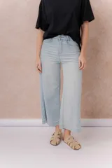 Pantalón jean tiro alto de color celeste claro, con corte wide leg y largo cropped. Presenta bolsillos funcionales y terminación de ruedo ancho.