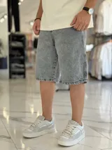Bermuda de jean de corte baggy y tiro medio, con diseño clásico de cinco bolsillos y lavado claro.