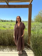 Vestido largo de lino color azul marino, con escote en V y mangas cortas amplias. Presenta un corte relajado y bolsillos laterales.