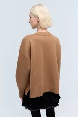 Sweater color camel de tejido de punto con cuello redondo y mangas largas. Presenta bordado de flor en el frente y la palabra 'Rebels' en la manga.