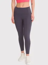 Calza deportiva gris oscuro con tiro alto, bolsillos laterales y banda de silicona interna en la cintura. Confeccionada en poliéster y spandex con certificación Bluesign.